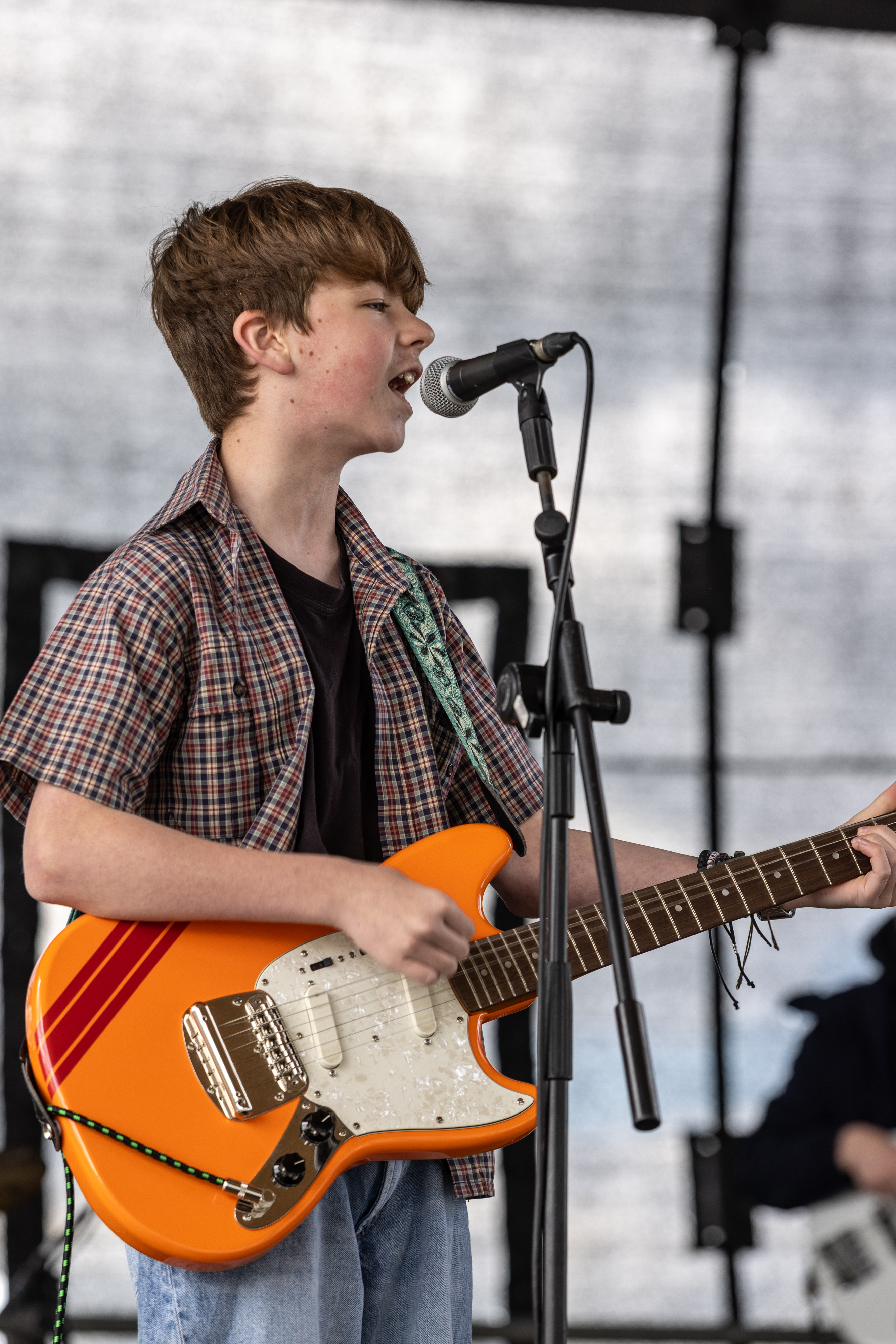 Person singing and playing guitar.